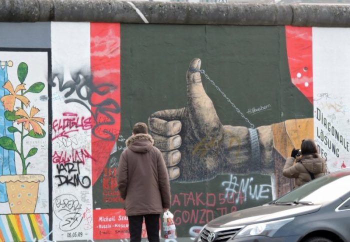 eine Person betrachtet Street Art Berlin