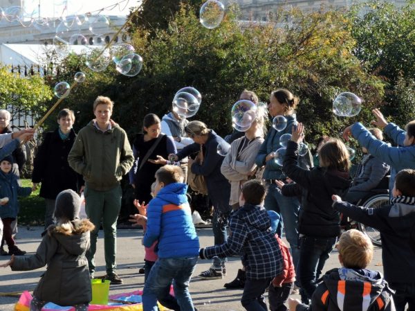 eine Gruppe Kinder fängt Riesen-Seifenblasen_Wien