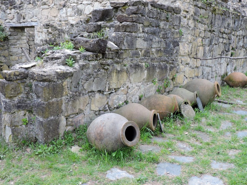 alte Amphoren vor alter Steinmauer liegend