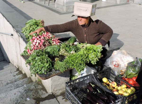 Gemüseverkäuferin mit Schachtel auf dem Kopf