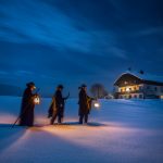 3 Männer unterwegs im Schnee zu einem Haus im Stille Nacht Land, Stille Nacht Entstehung