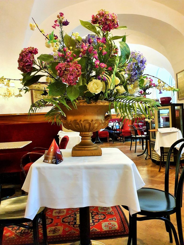 großer Blumenstrauß in Vase auf dem Kaffeehaus-Tisch