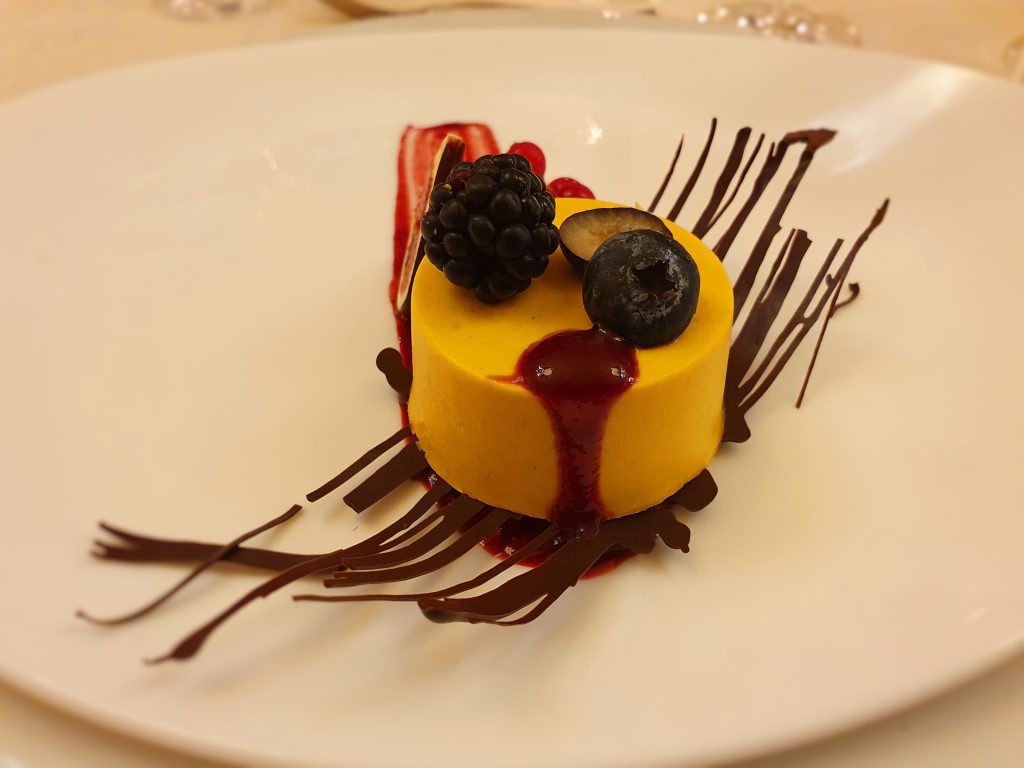 rundes Dessert mit Schokolade-Frucht-Dekoration