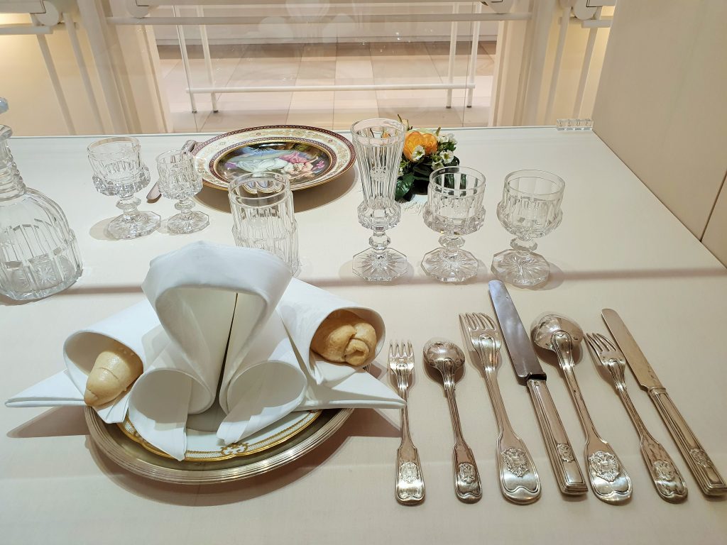 edel gedeckter Tisch mit Silberbesteck u. kunstvoller Serviette