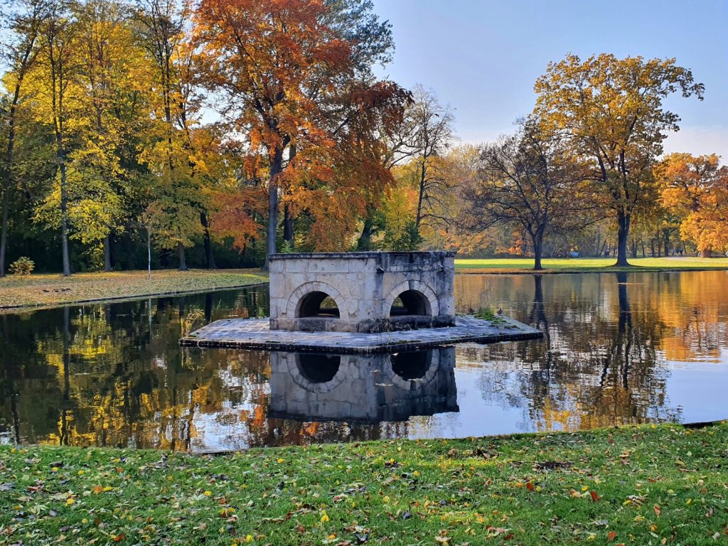 Teich in einem herbstlichen Park mit Brunnen