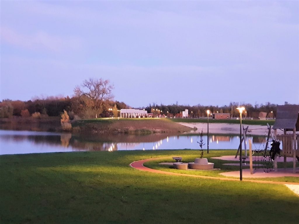 Parkanlage mit Teich im Abendlicht