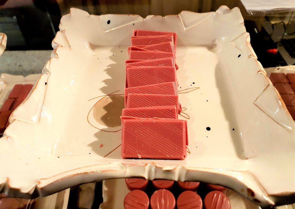 rosa Schokoladenstücke auf weißem Tablett