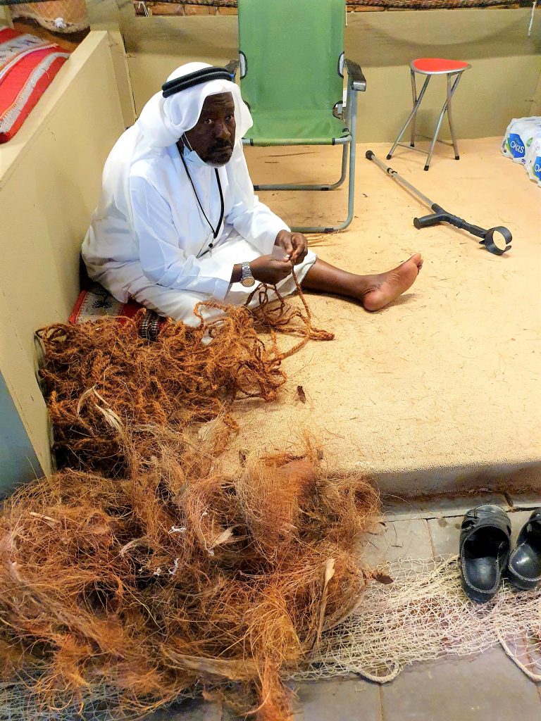 Fischer aus Abu Dhabi knüpft ein Fischernetz