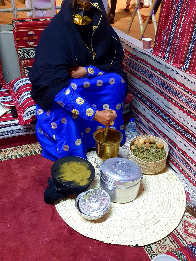 verschleierte Beduinenfrau stellt Henna her