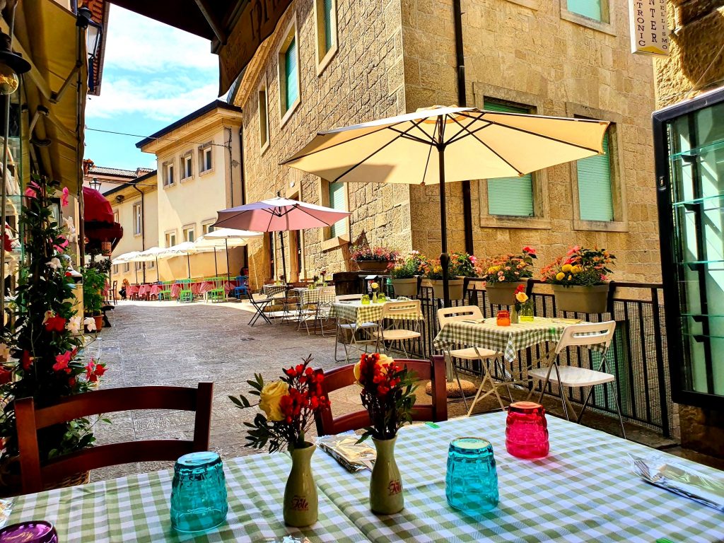bunt gedeckter Tisch mit Sonnenschirm in Italien