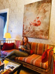 Reisebloggerin Tee trinkend in einem luxuriösen Salon