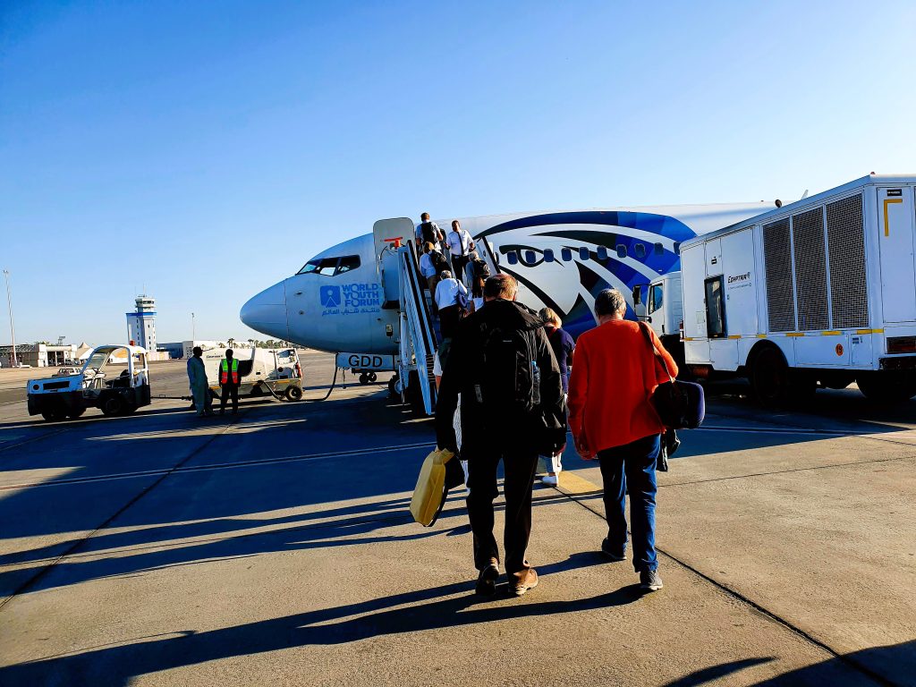 Touristen gehen zu einem Flugzeug einer ägyptischen Airline
