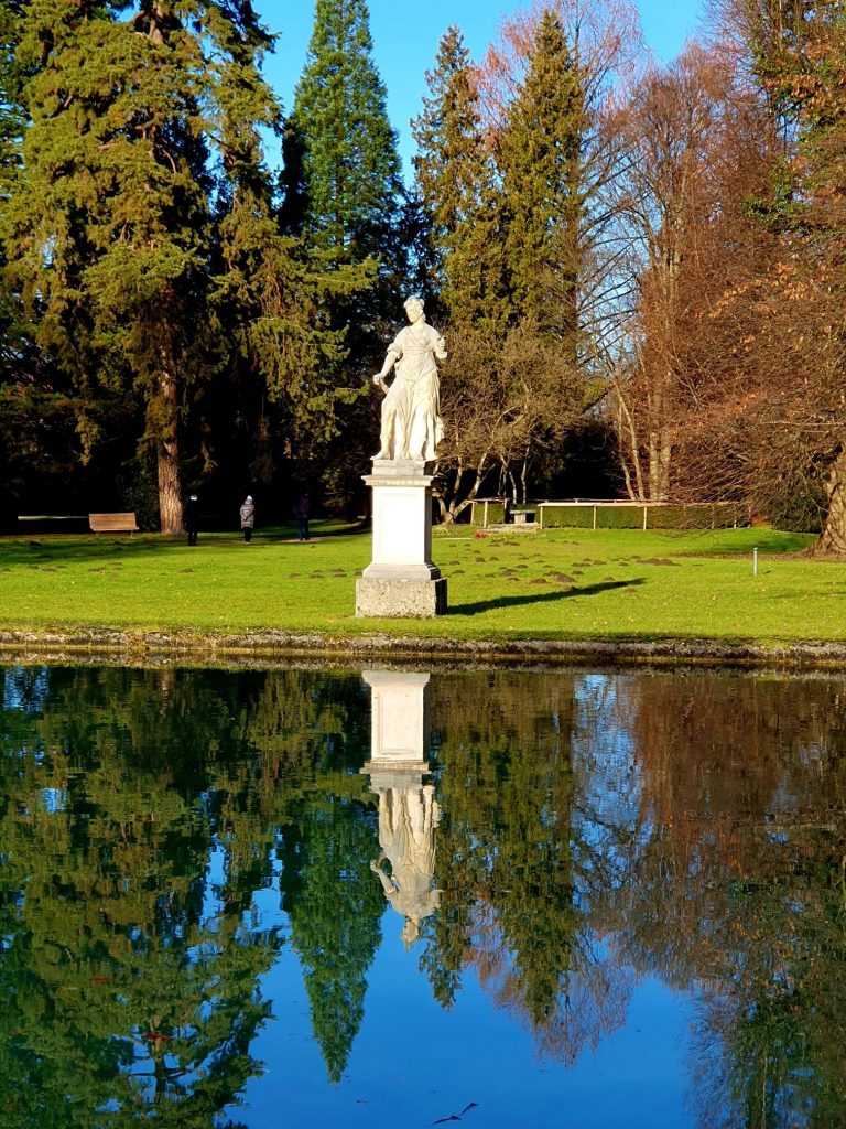 steinerne Statue einer Grazie am Teich im Schlosspark Hellbrunn