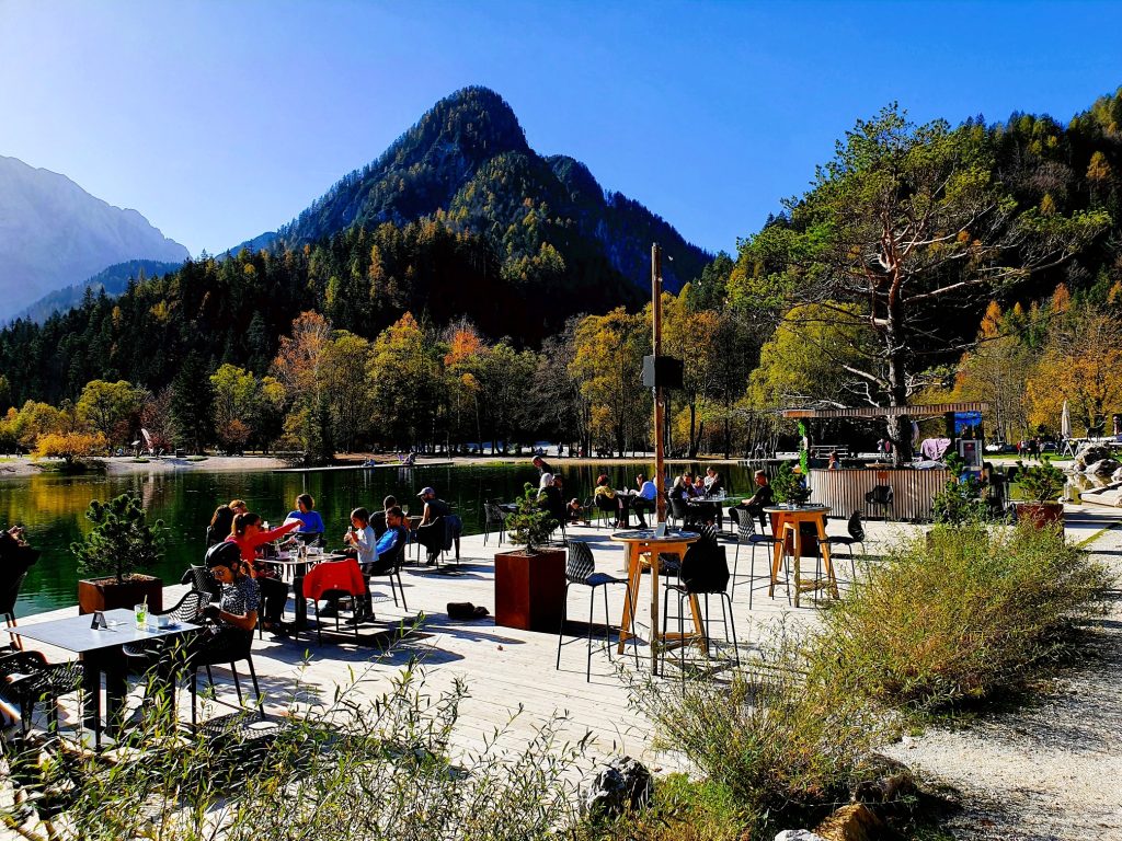 Seestrand Restaurant mit Menschen in der Sonne sitend, Jasna See Krajnska Gor