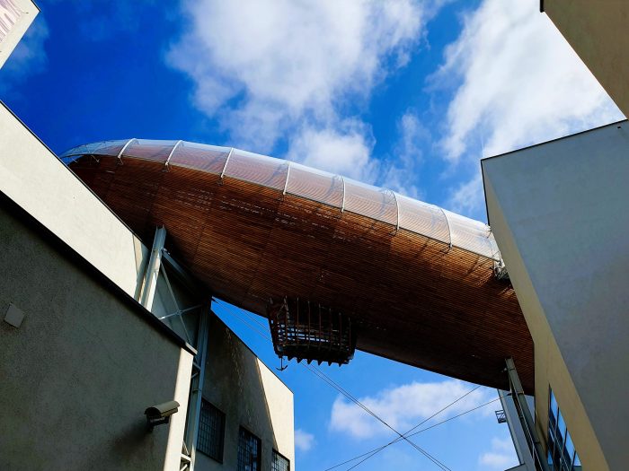 ein Zeppelin verbindet zwei moderne Gebäude im Prag Hipster Viertel