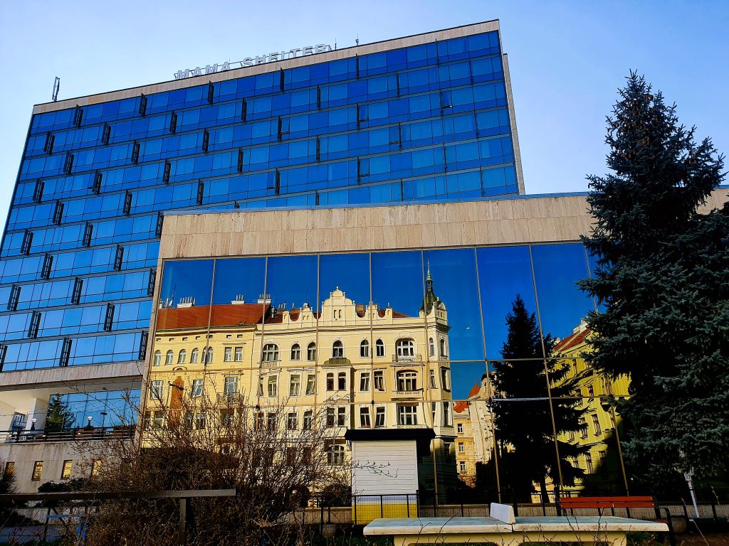 ein historisches Gebäude spiegelt sich in moderner Glasfassade