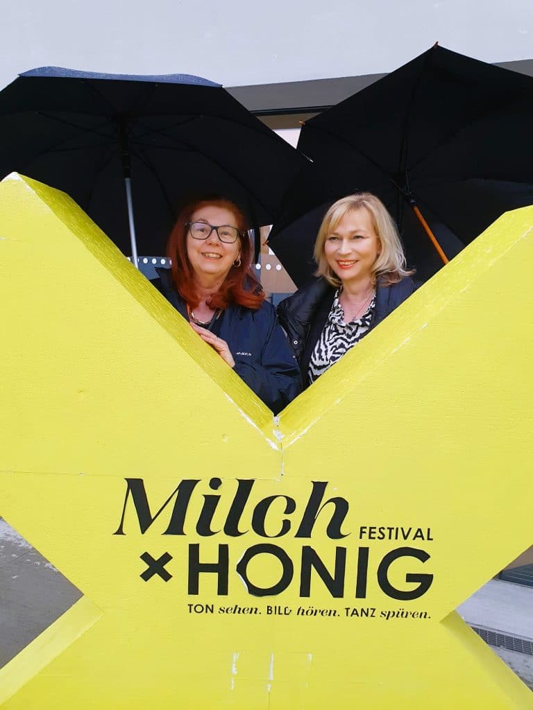 zwei Frauen schauen über ein Schild, Milch & Honig Festival Wiener Neustadt