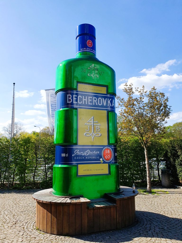 überdimensionale grüne Likörflasche als Werbung auf einem Podest