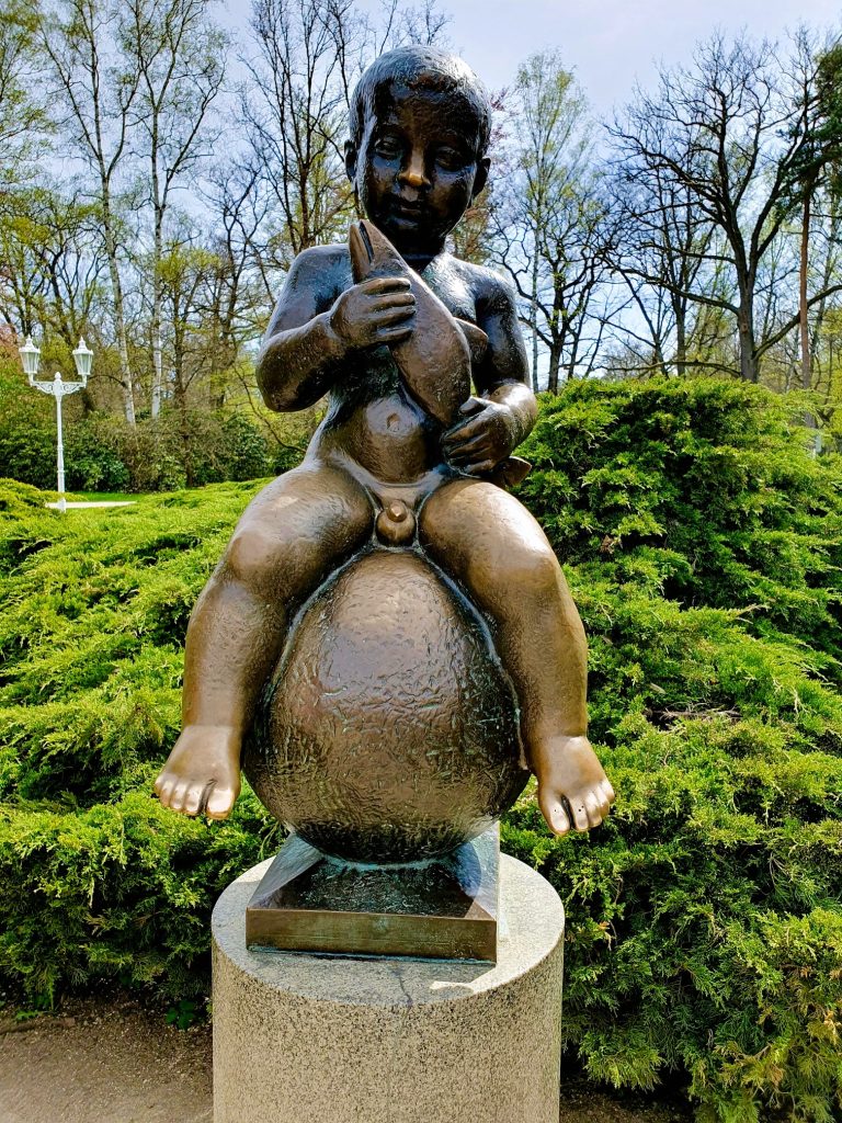 Bronze-Statue mit sitzendem, nackten Knaben