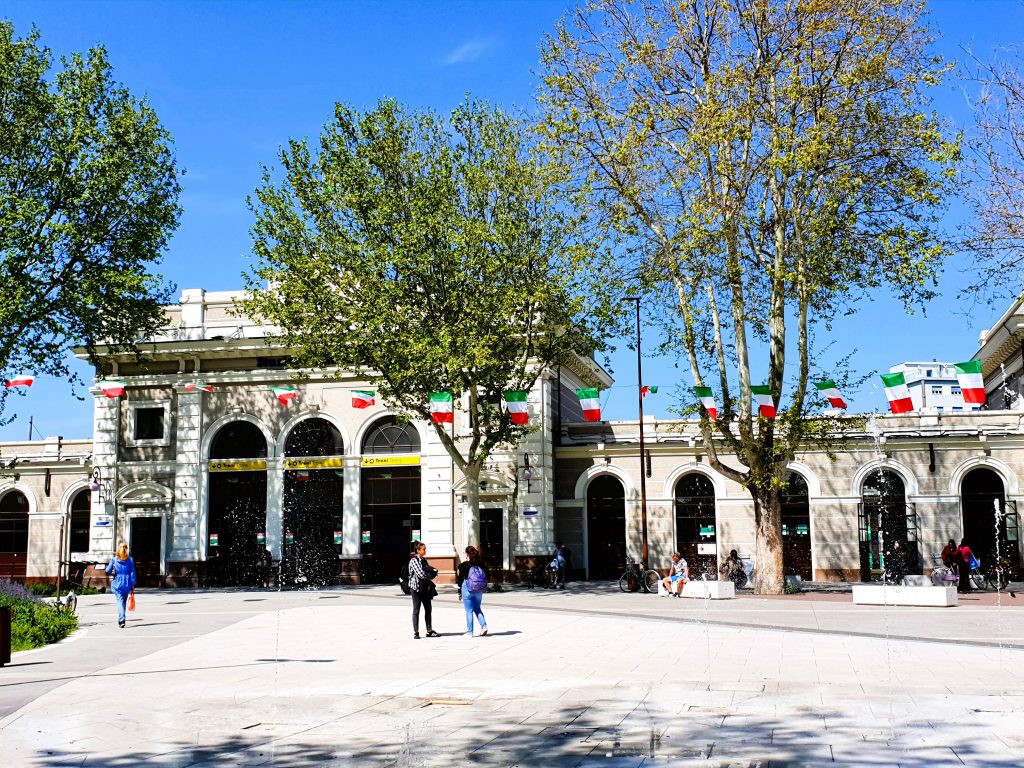 Bahnhofsgebäude mit grünen Bäumen davor, Rimini Sehenswürdigkeiten