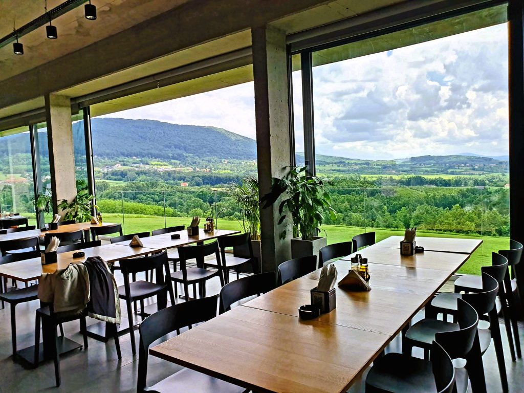 gemütlicher Tisch in Gasthaus mit schönem Blick hinaus in die grüne Landschaft