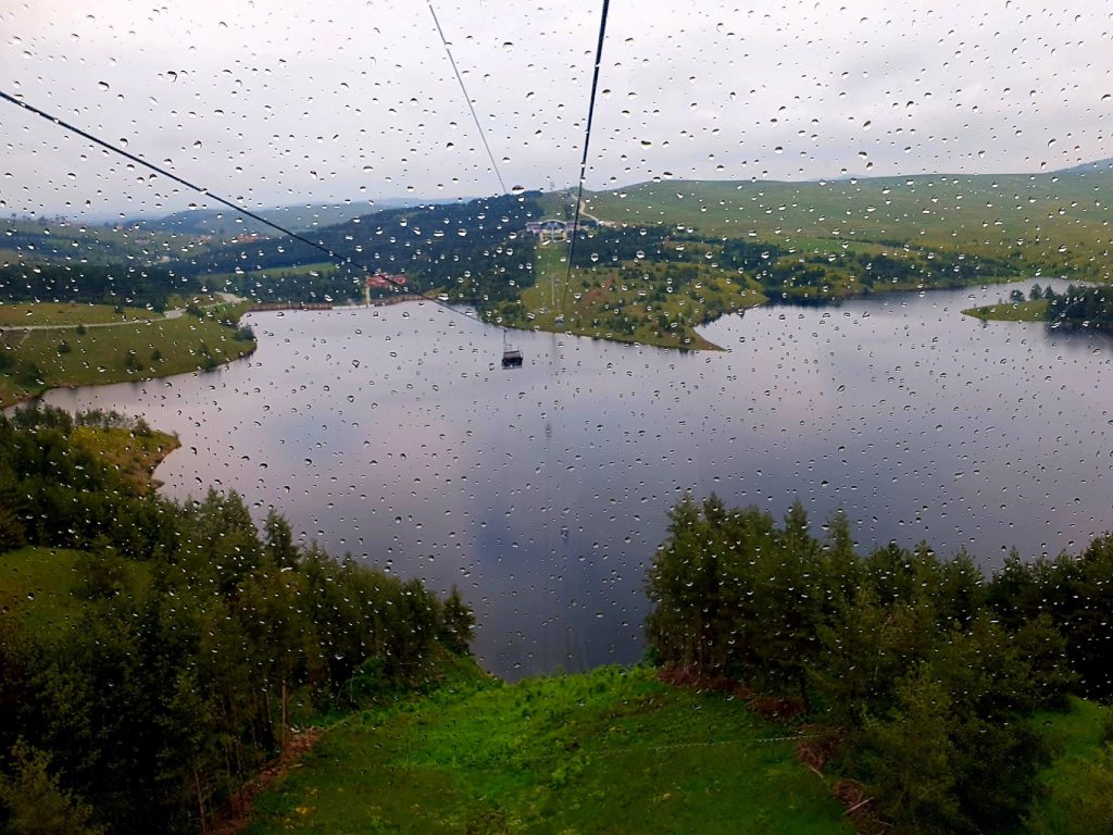 Blick aus einer Panorama-Gondel über einen See in grüner Landschaft