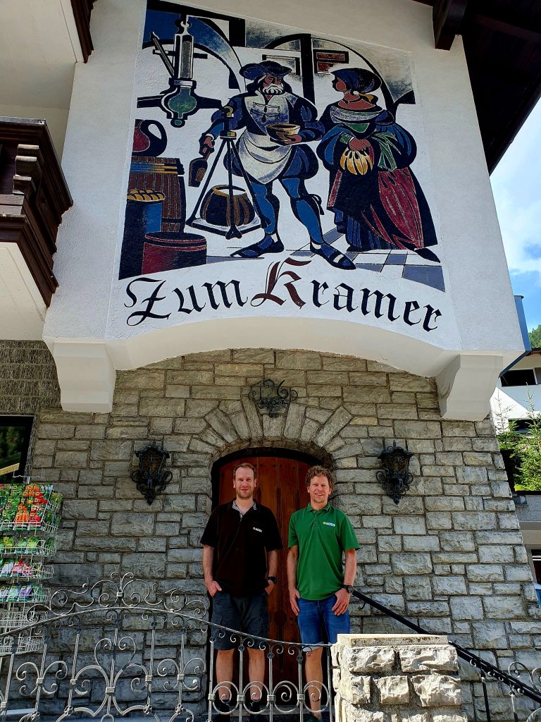 zwei Männer stehen vor einem Haus mit der Aufschrift "Zum Krämer"