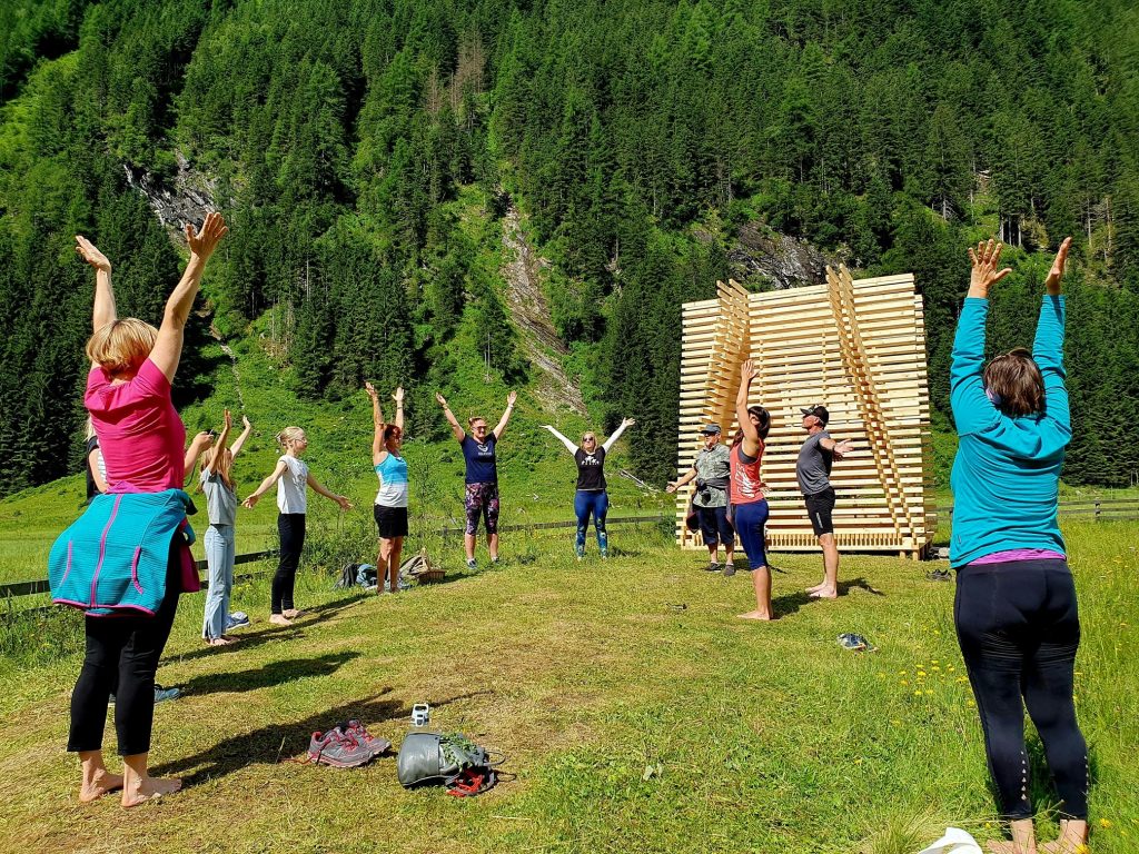 Eine Menschengruppe macht Yoga-Übungen in der Natur