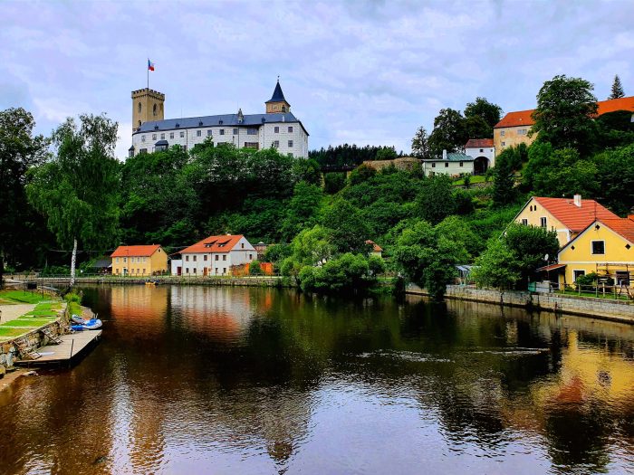 Blick auf malerische Landschaft mit Fluss und Burg Rozmberk auf dem Hügel