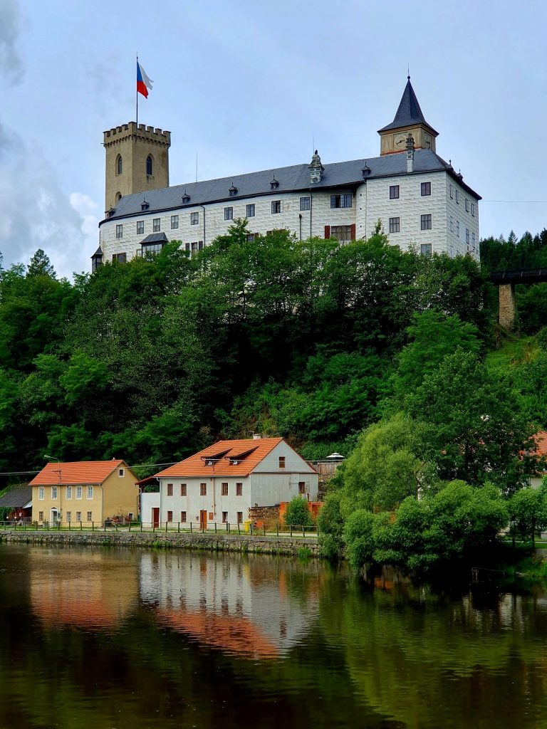Eine Burg thront auf einem Hügel über einem malerischen Fluss - Burg Rozmberk
