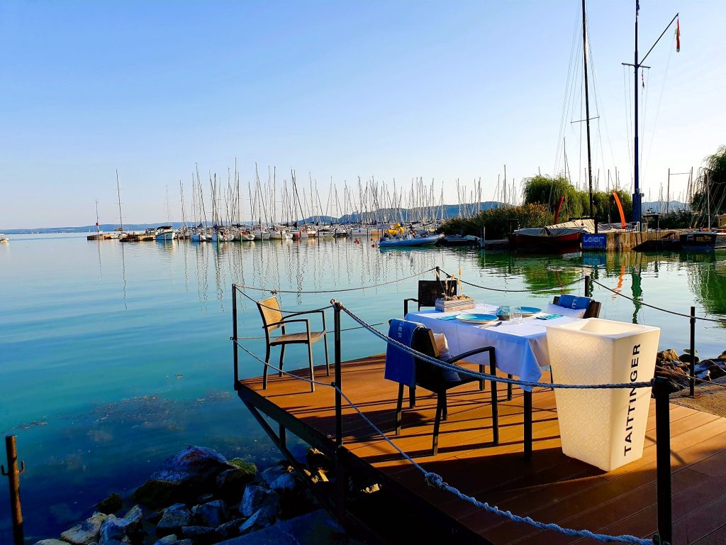 See mit Steg, auf dem ein Restaurant-Tisch steht, Veszprem-Balaton Region