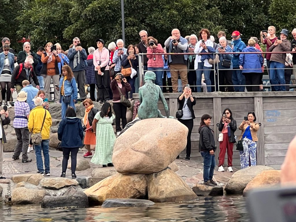Touristen stehen zum Fotografieren um die Kleine Meerjungfrau in Kopenhagen