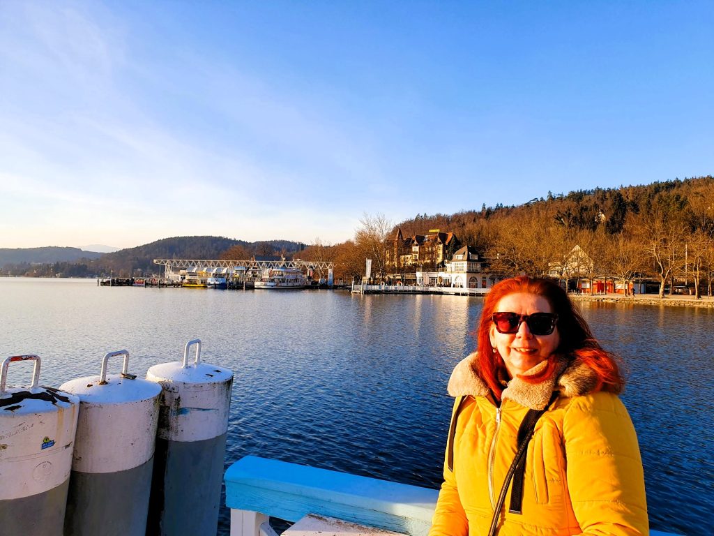 Reisebloggerin steht vor schöner See-Kulisse, Wörthersee