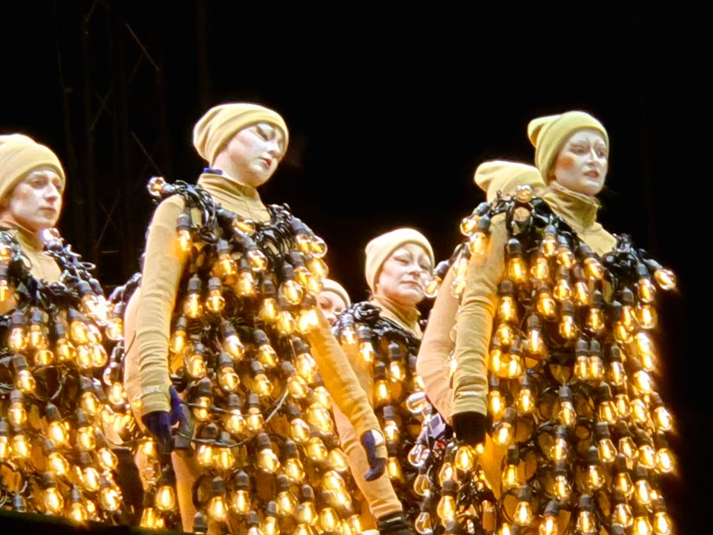 Performance mit Darstellern in Lampen-Kleidern