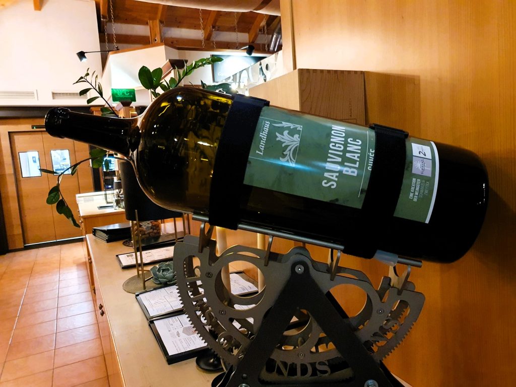 riesige Weinflasche auf einer Weinhalterung positioniert