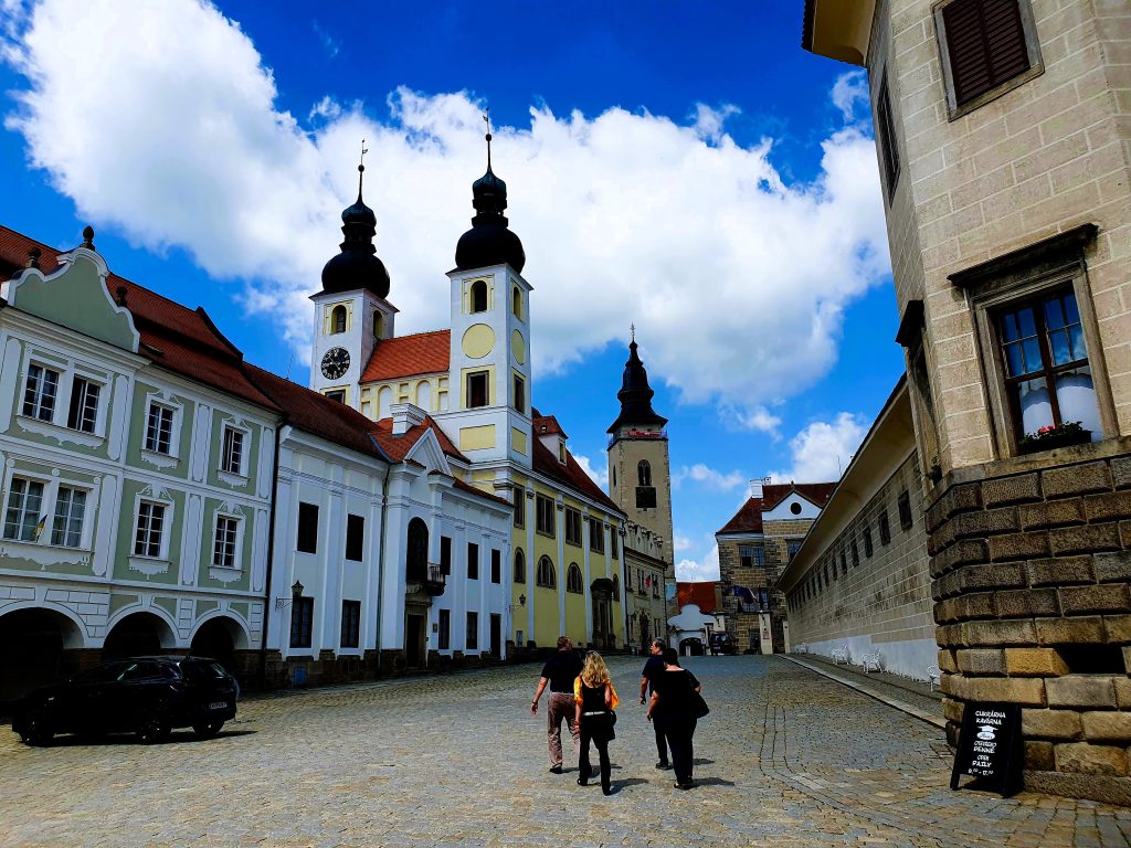 Menschen spazieren durch eine Altstadt mit Kirche, Telc