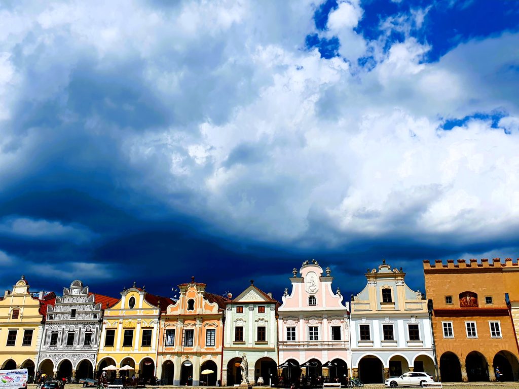 Häuserzeile mit bunten historischen Gebäuden und dramatischem Wolkenhimmel, Telc